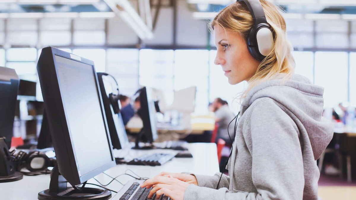 Girl working on computer with headphone