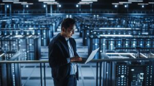 man in server room with laptop