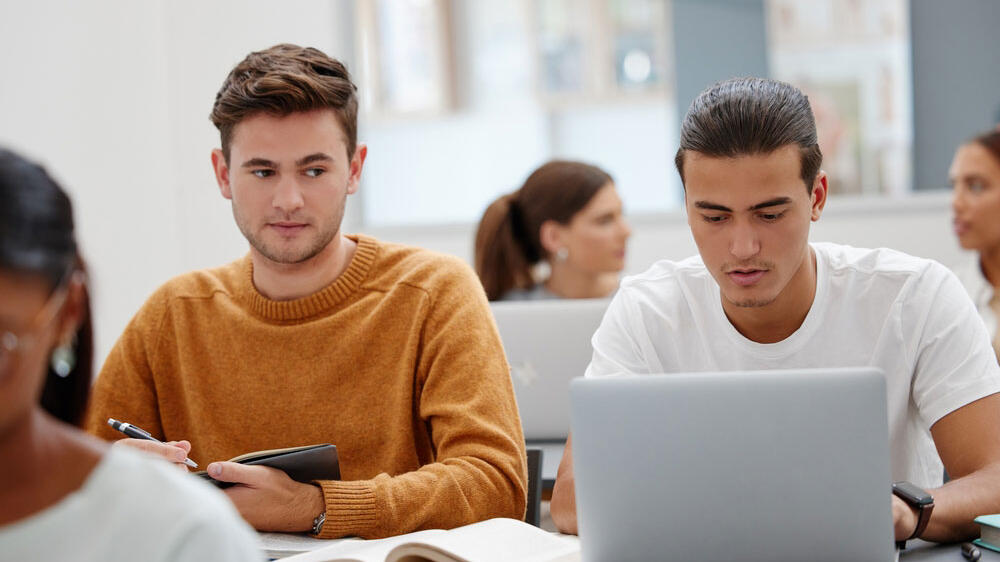 student peeking at another student's laptop