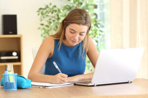 young female student taking online test at home